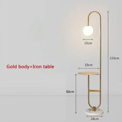 Gold finished floor lamp with curved metallic frame, spherical white bulb, and marble base for living room use