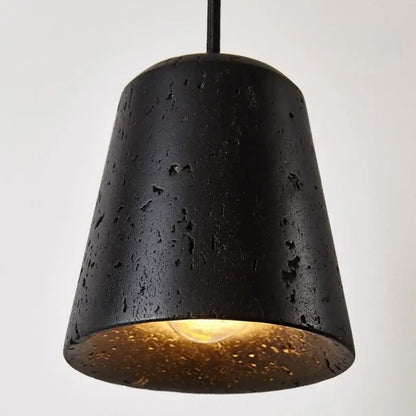 Black travertine pendant light with textured speckled surface and warm gold interior lining for dining room decorbites black travertine