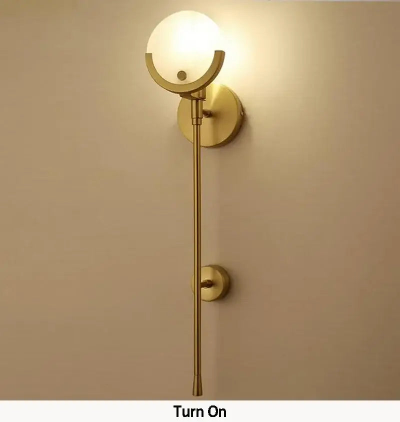 Nordic brass and marble wall lamp with gold finish, spherical frosted glass shade, and minimalist curved metal decorbites creative marble design