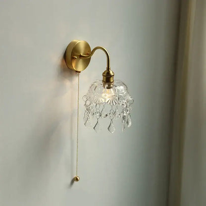 Gold-toned nordic brass crystal glass led wall light with clear faceted shade and dangling crystal droplets decorbites crystal glass