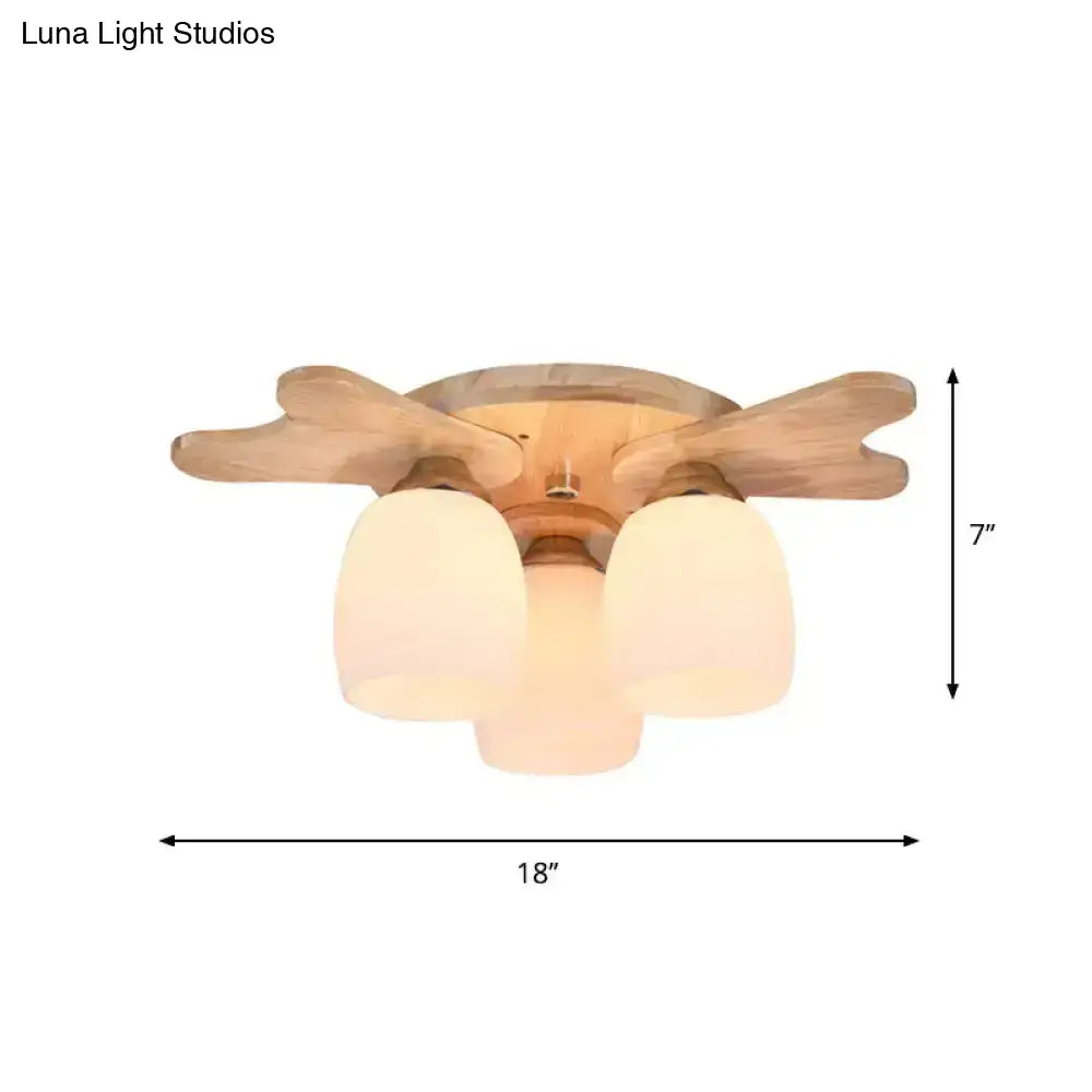 Light wood-finish ceiling fan with three frosted cream glass bell shades for bedroom lighting with wood antler design