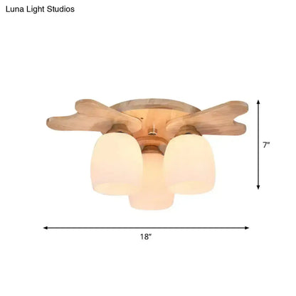 Light wood-finish ceiling fan with three frosted cream glass bell shades for bedroom lighting with wood antler design