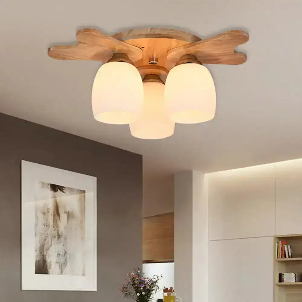 Wooden ceiling light with natural finish featuring three cream glass bell shades for bedroom use