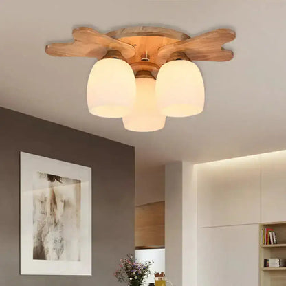 Wooden ceiling light with natural finish featuring three cream glass bell shades for bedroom use