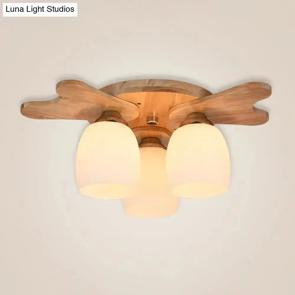 Nordic cream glass bell ceiling light with wooden antler arms and three warm-toned cream glass shades for bedroom