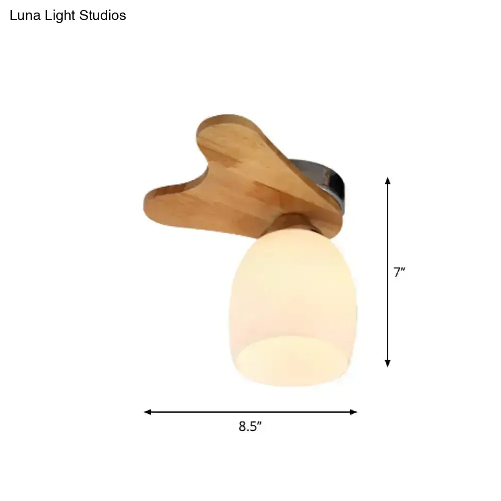 A cream glass bell ceiling light with a wood antler wing-shaped shade and frosted glass globe for bedroom use