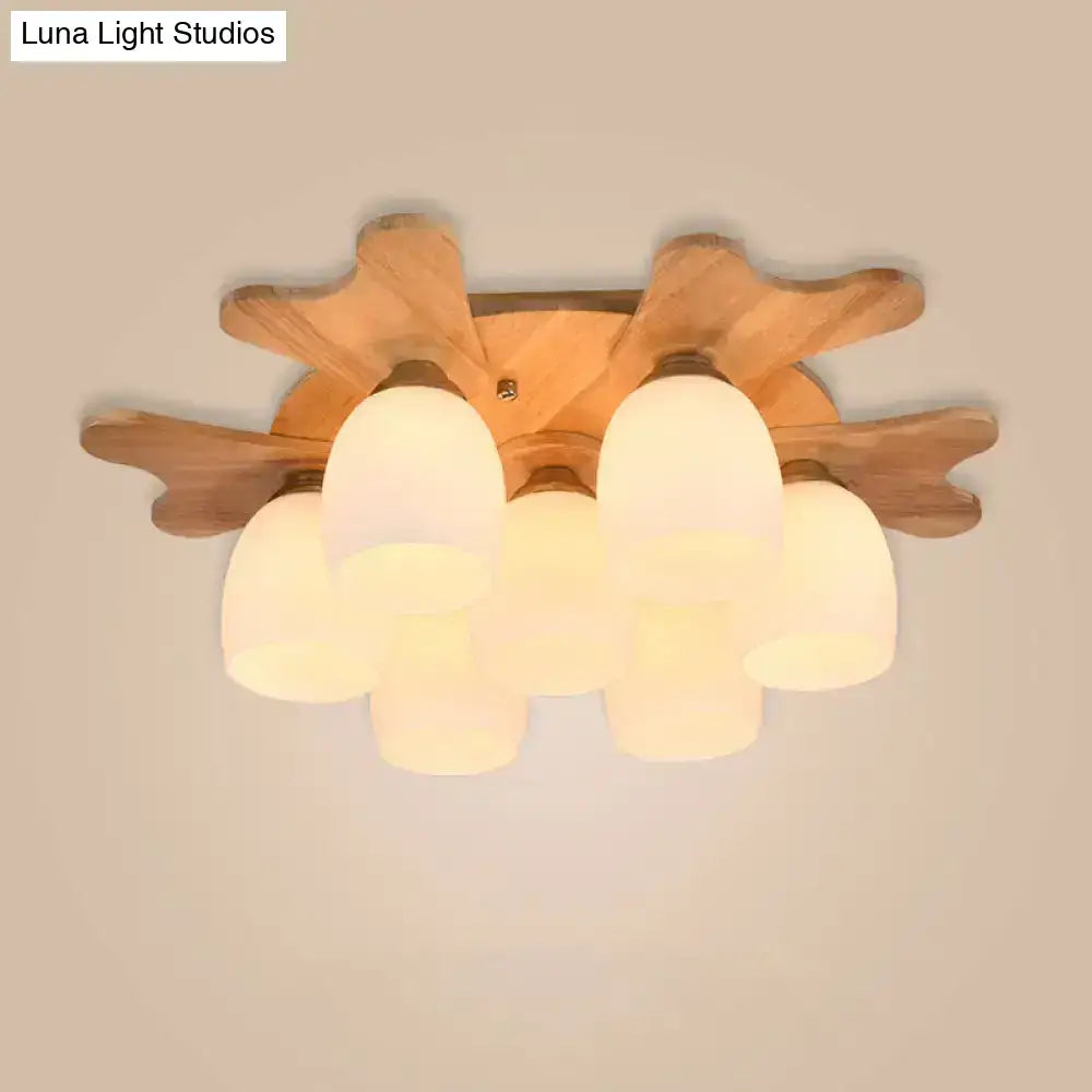 Wooden leaf-shaped ceiling light with five cream glass bell frosted shades for bedroom lighting