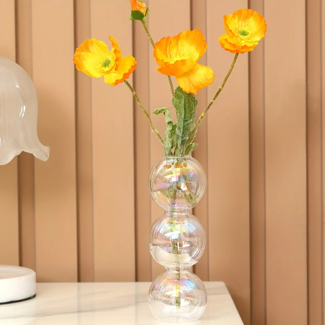 Clear glass nordic glass bubble vase with three stacked spherical sections holding vibrant yellow flowers for home decor