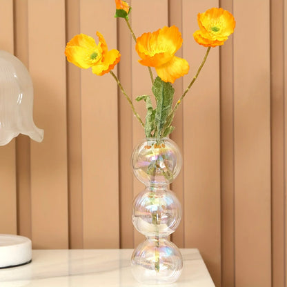 Clear glass nordic glass bubble vase with three stacked spherical sections holding vibrant yellow flowers for home decor