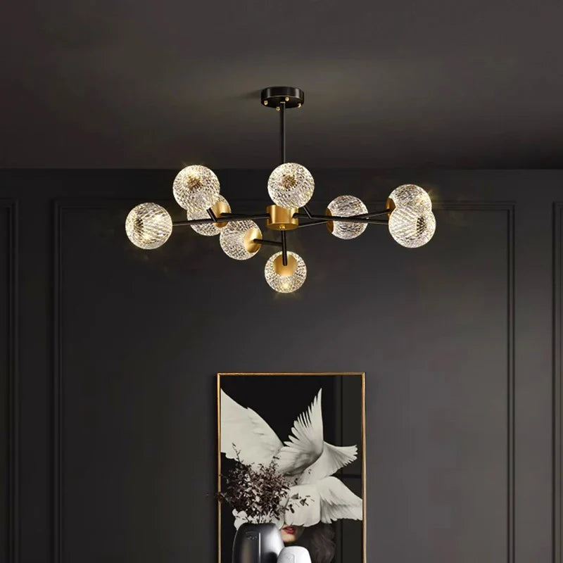 Modern chandelier with clear textured glass globe shades on black and gold metal frame for living room lighting