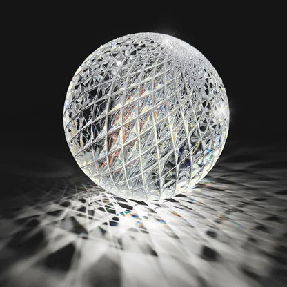 A clear crystal sphere pendant lamp with geometric lattice pattern refracting rainbow light for nordic dining room decor