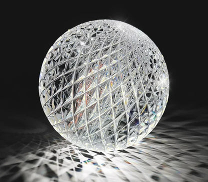 A clear intricately cut crystal sphere with geometric lattice in nordic pendant lamp for dining room lighting