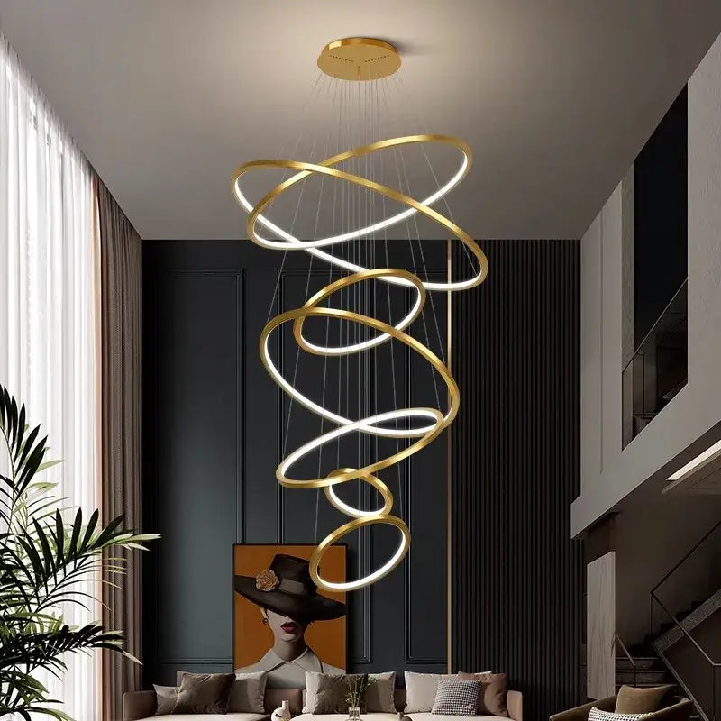 Golden spiral ring chandelier with illuminated rings in nordic home decor style for staircase lighting by decorbites nordic home