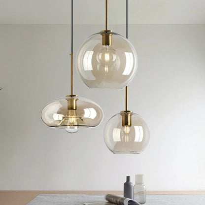 Three nordic led glass pendant lights with clear glass globes and brass accents for dining room decor