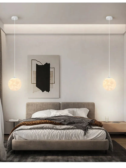 Two spherical white nordic led moon pendant chandeliers with soft glow hanging above a bed for dining room kitchen use