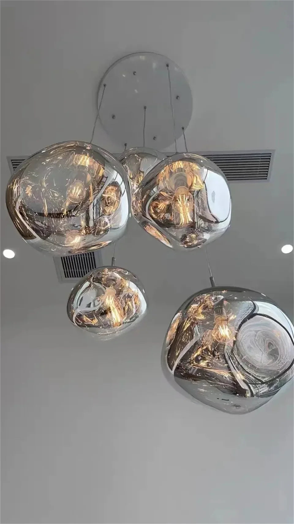 Set of five spherical reflective chrome glass Nordic LED pendant lights with warm interior illumination for indoor use