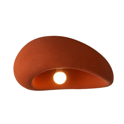 Terracotta ceramic wall sconce with matte finish and smooth curves complements nordic ceiling light for bedroom
