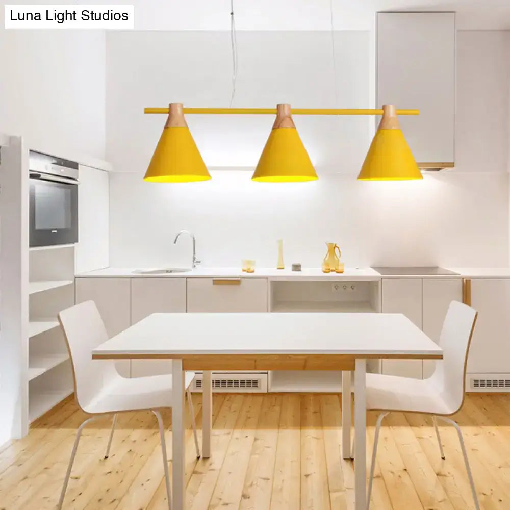 Bright yellow conical metal pendant lights with wooden accents hang above a white dining table for kitchen island lighting