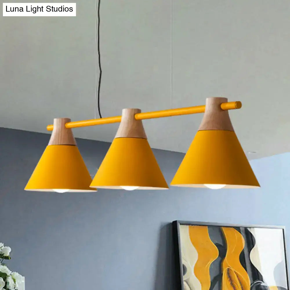 Vibrant yellow conical metal pendant lights with natural wood accents hanging from a sleek bar for kitchen island lighting