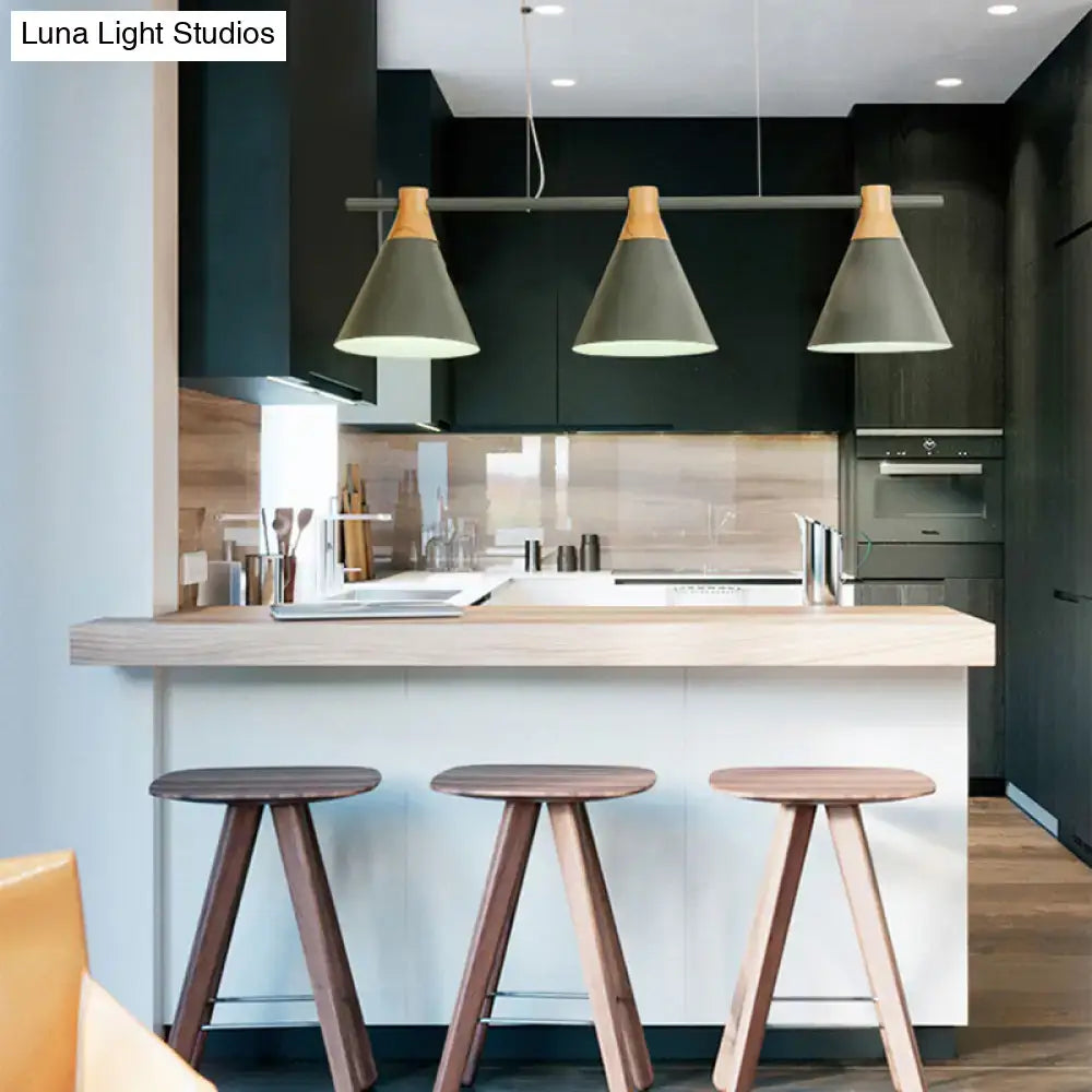Three decorbites™ nordic metal pendant lights with matte gray cone shades and wood tops hang above a kitchen island