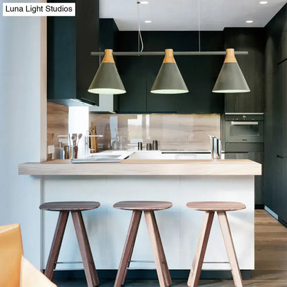 Three decorbites™ nordic metal pendant lights with matte gray cone shades and wood tops hang above a kitchen island