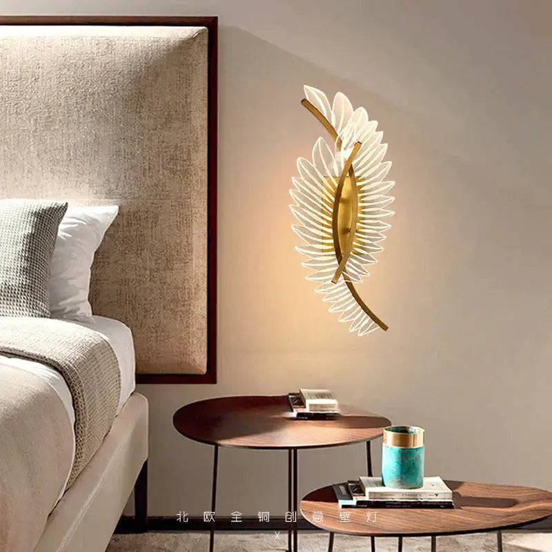 Nordic modern art gold feather wall lamp with gold-toned leaf design and translucent white petal arms for bedside use