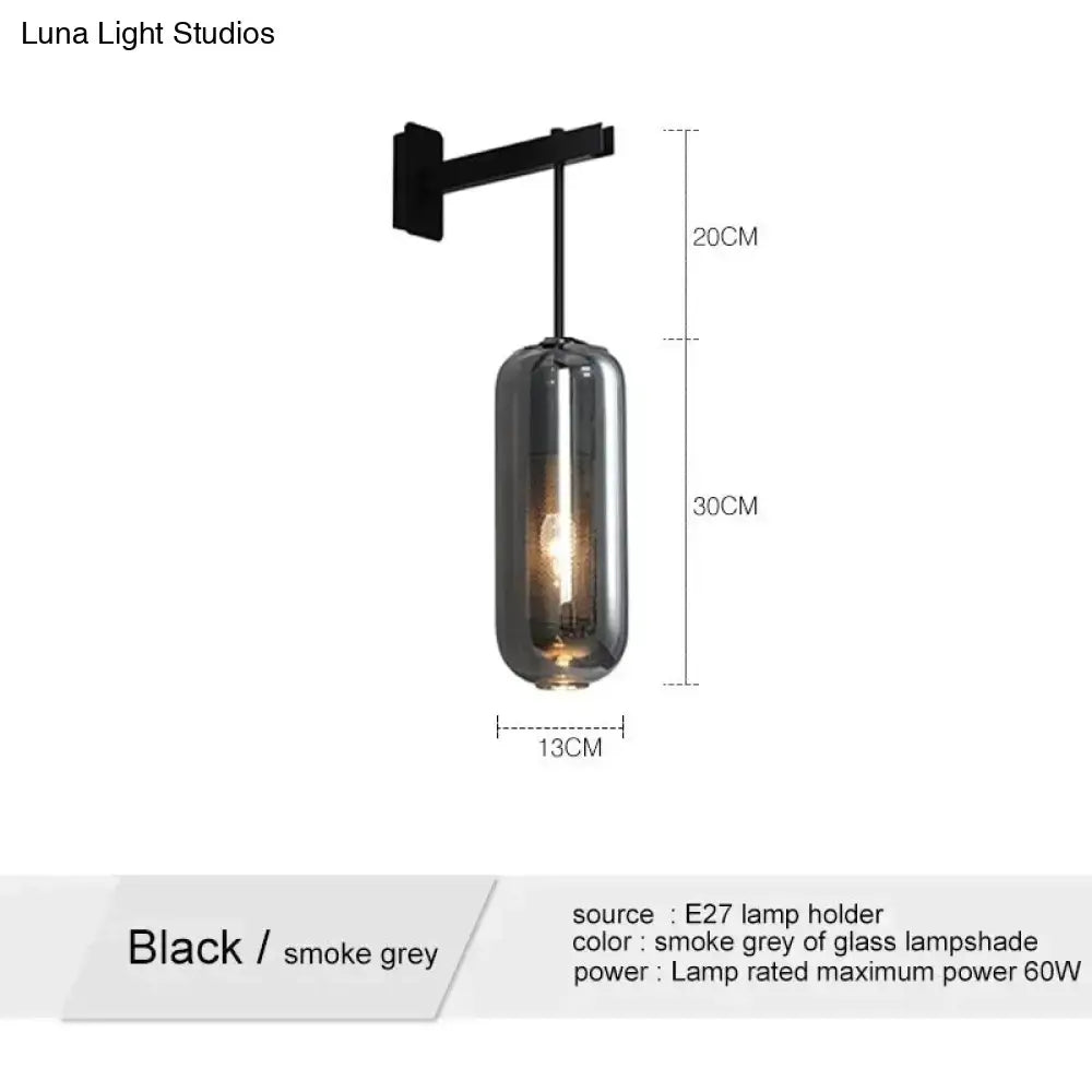Black metal wall-mounted sconce with a cylindrical smoke grey glass lampshade for nordic modern decor bedroom use