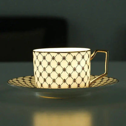 Cream-colored bone china coffee cup with gold rim handle and black diamond lattice pattern from nordic navy gold set