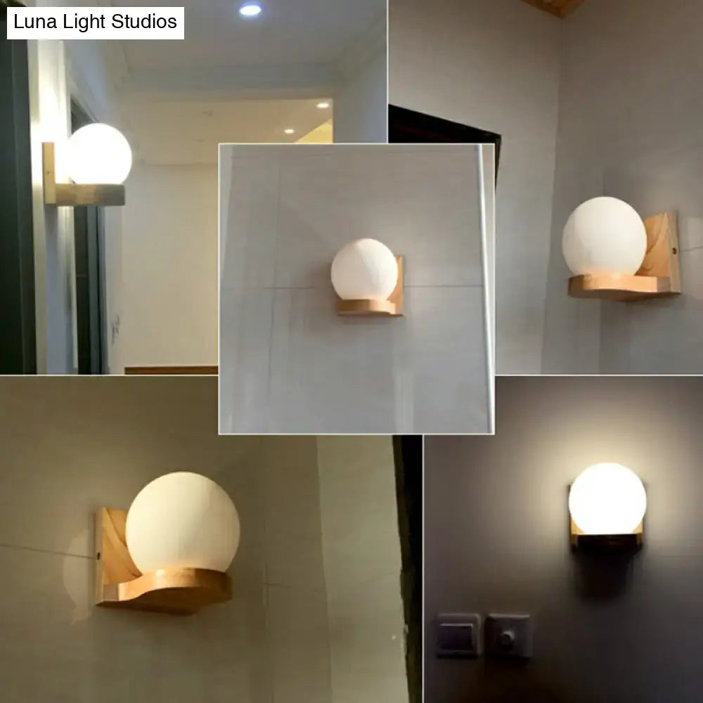 Minimalist wall light wall sconce with frosted white opal glass globe and natural wood base for bedroom use