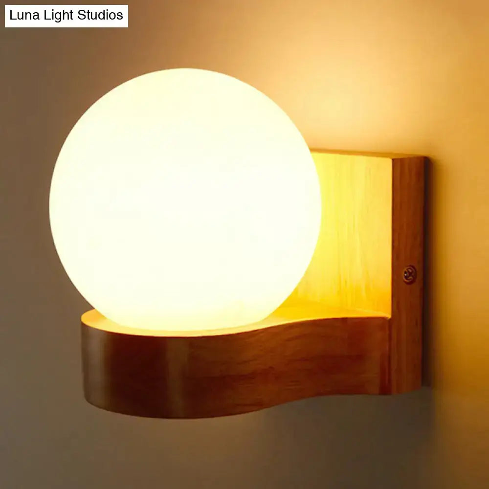 Nordic opal glass and wood wall sconce with warm-toned spherical led frosted glass globe mounted on natural wood base wall light