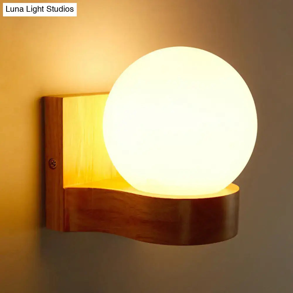 Warm-toned spherical opal glass wall light mounted on wooden wall sconce for bedroom lighting