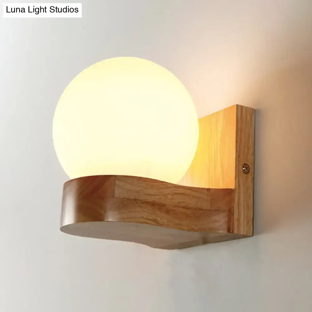 Nordic opal glass wall sconce with warm-toned spherical globe on natural wood base minimalist wall light for bedroom