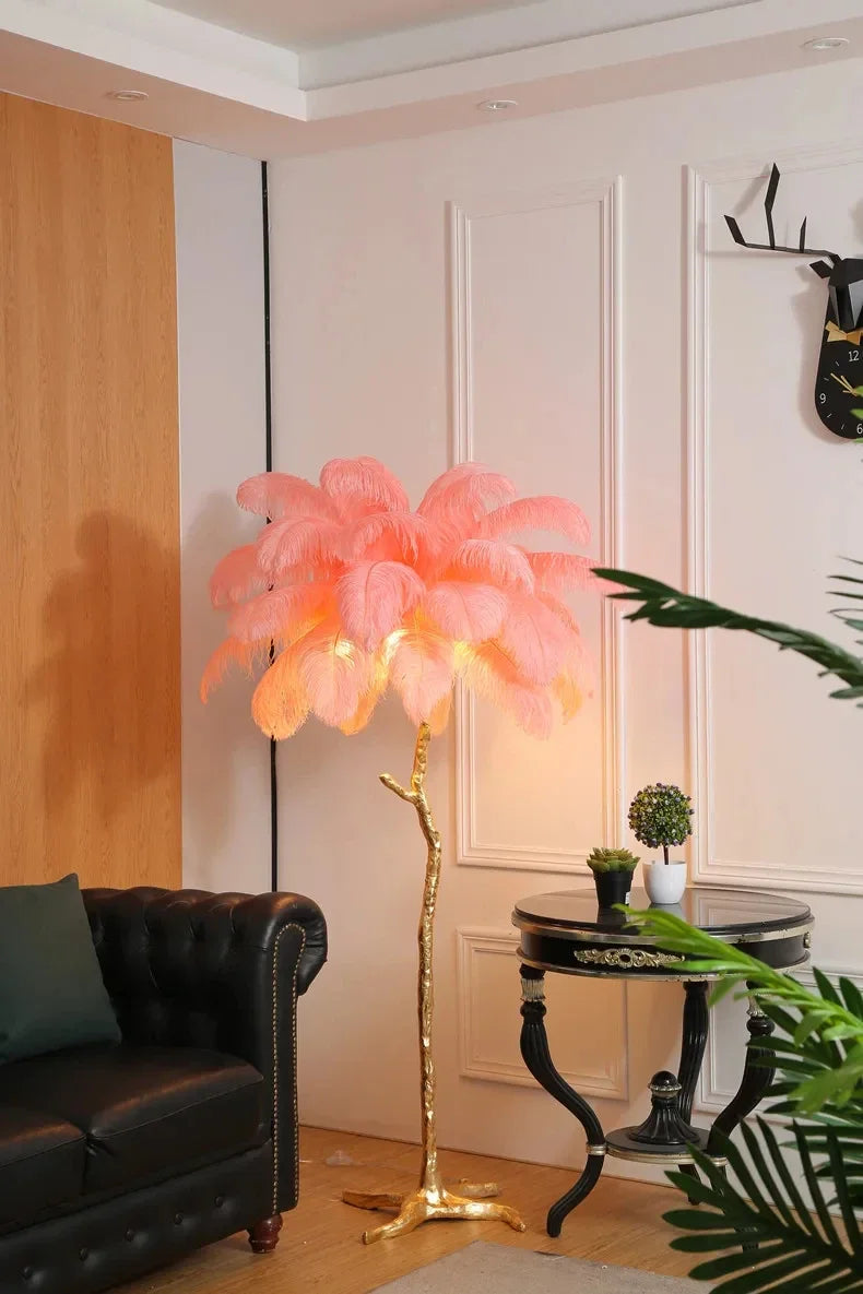 A glowing pink feather floor lamp with a golden tree-like base for living room and bedroom decor