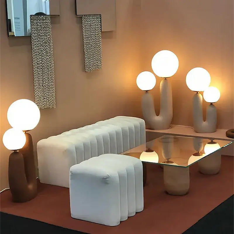 Modern white tufted sofa with segmented upholstery beside a nordic pink and green glass ball table lamp for bedroom decor