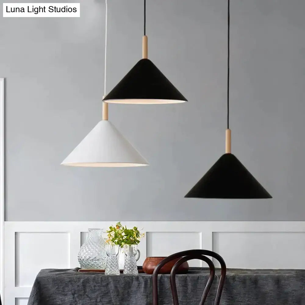 Three nordic simple kitchen pendant lights with matte black and white finishes and wooden dowel accents