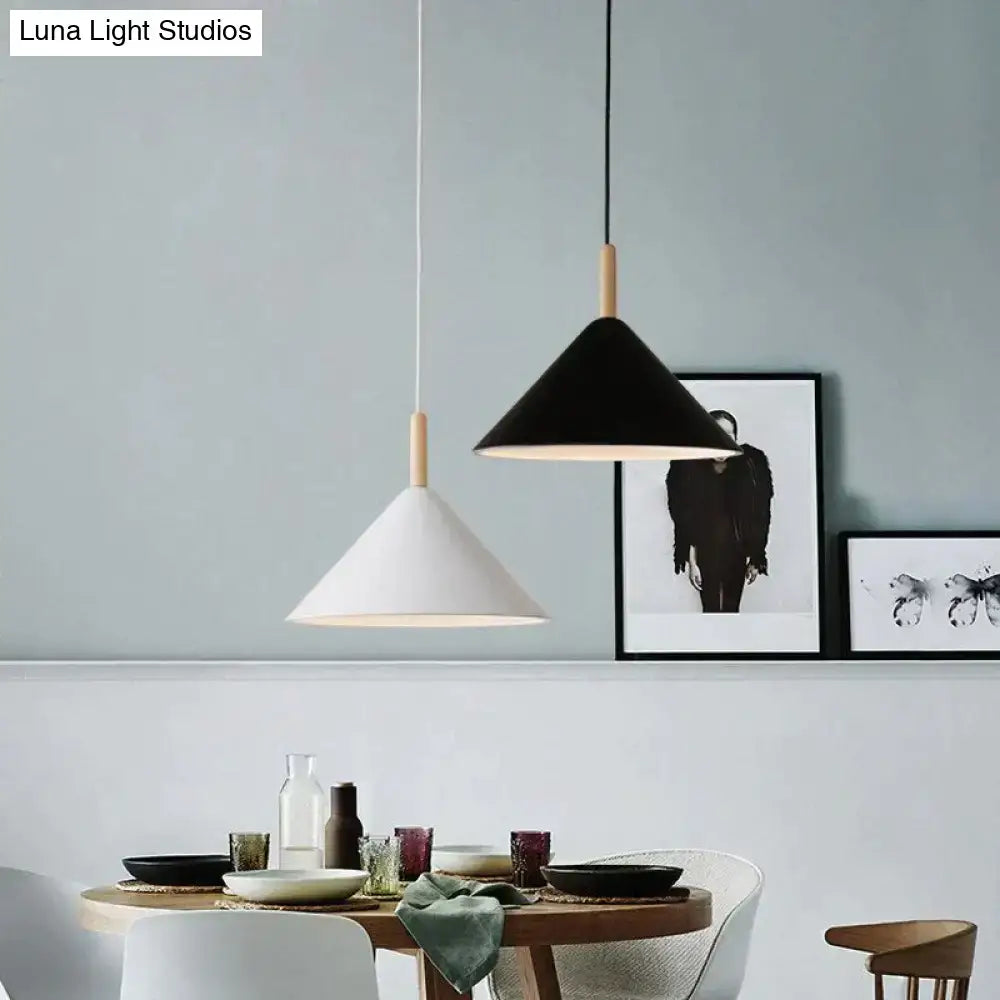 Two minimalist nordic simple kitchen pendant lights with black and white matte conical shades and wooden dowel suspension