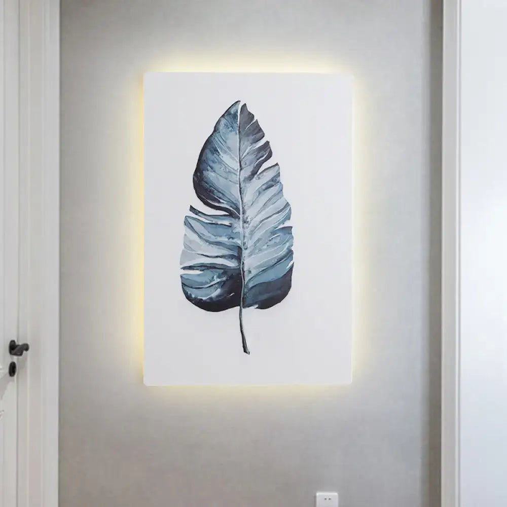 A nordic style banana leaf led wall art inch fixture featuring a blue-green stylized leaf with brushstroke texture and backlighting