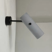 Nordic style matte black rotatable wall spotlight with a circular base and frosted white cylindrical diffuser for bedroom lighting