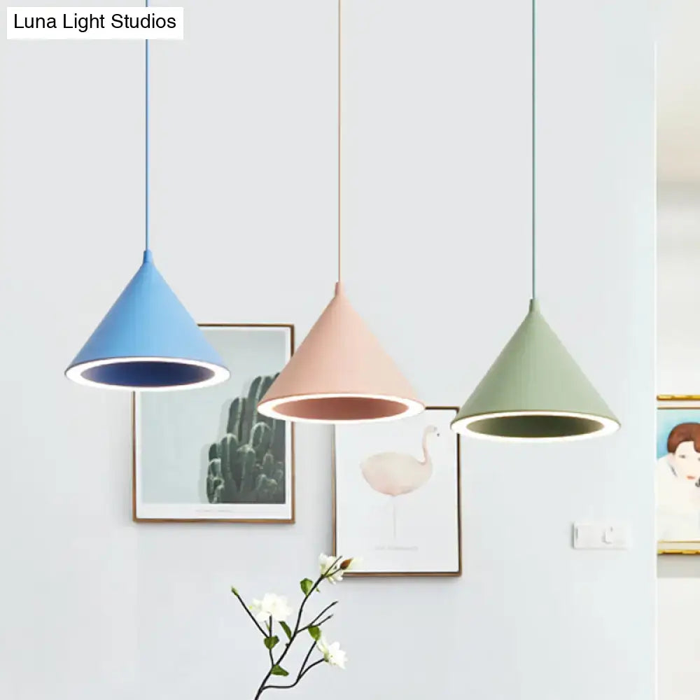 Three modern nordic stylish hanging lamps in soft blue blush pink and sage green metal pendant lights over table