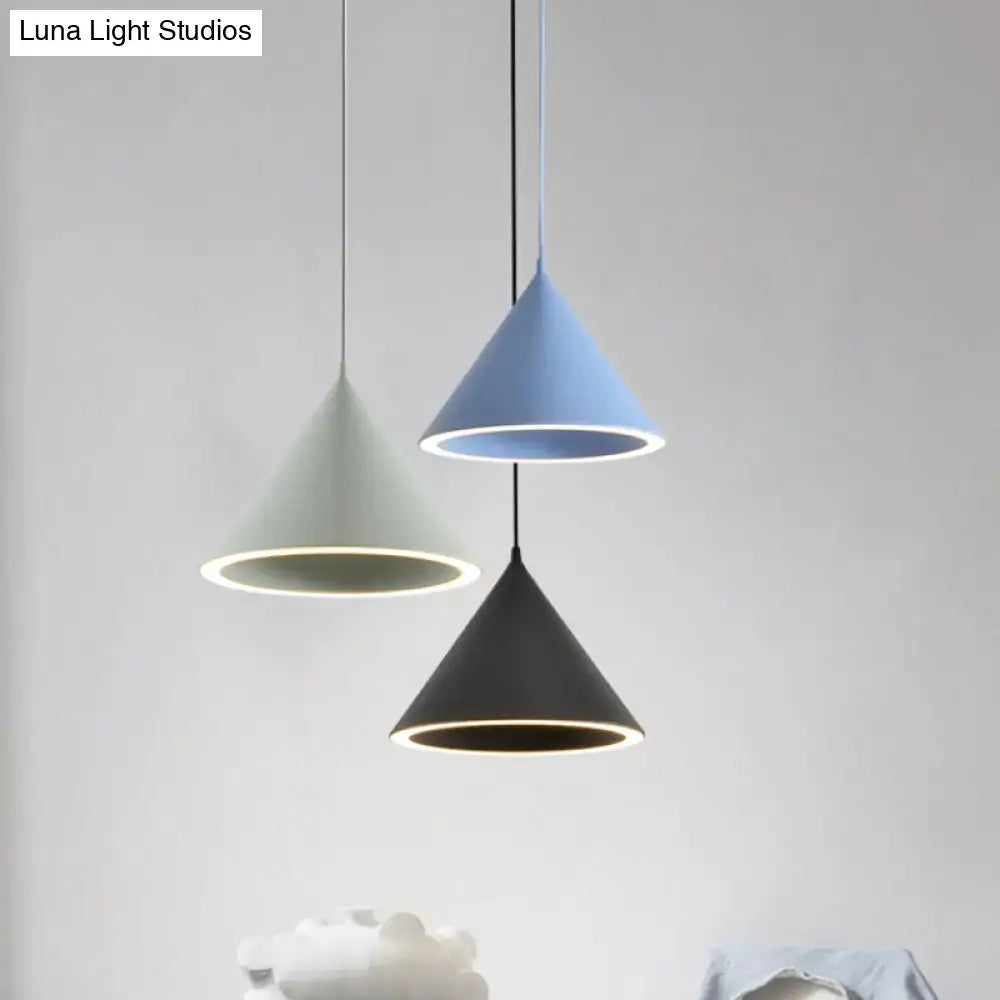 Three nordic stylish cone-shaped pendant lights in matte pastel green, soft blue, and black metal with illuminated rims