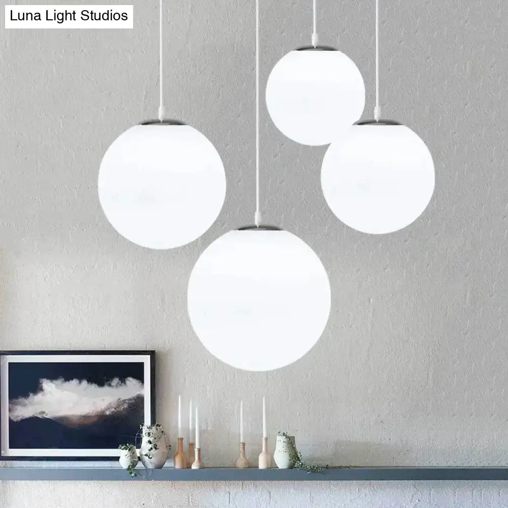 Set of four nordic white glass ball pendant lights with frosted glass shades and minimalist metal fixtures