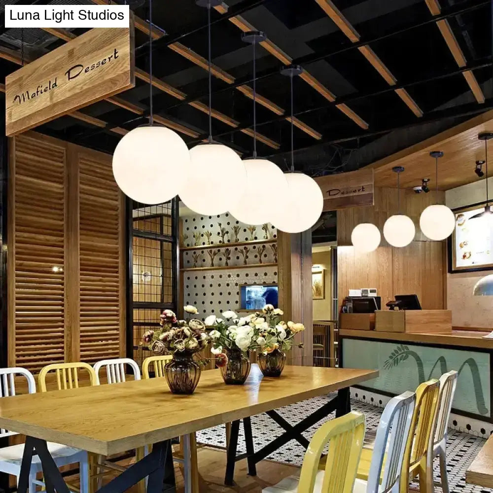 Modern white spherical nordic white glass ball pendant lights hang in a row for living room and restaurant use
