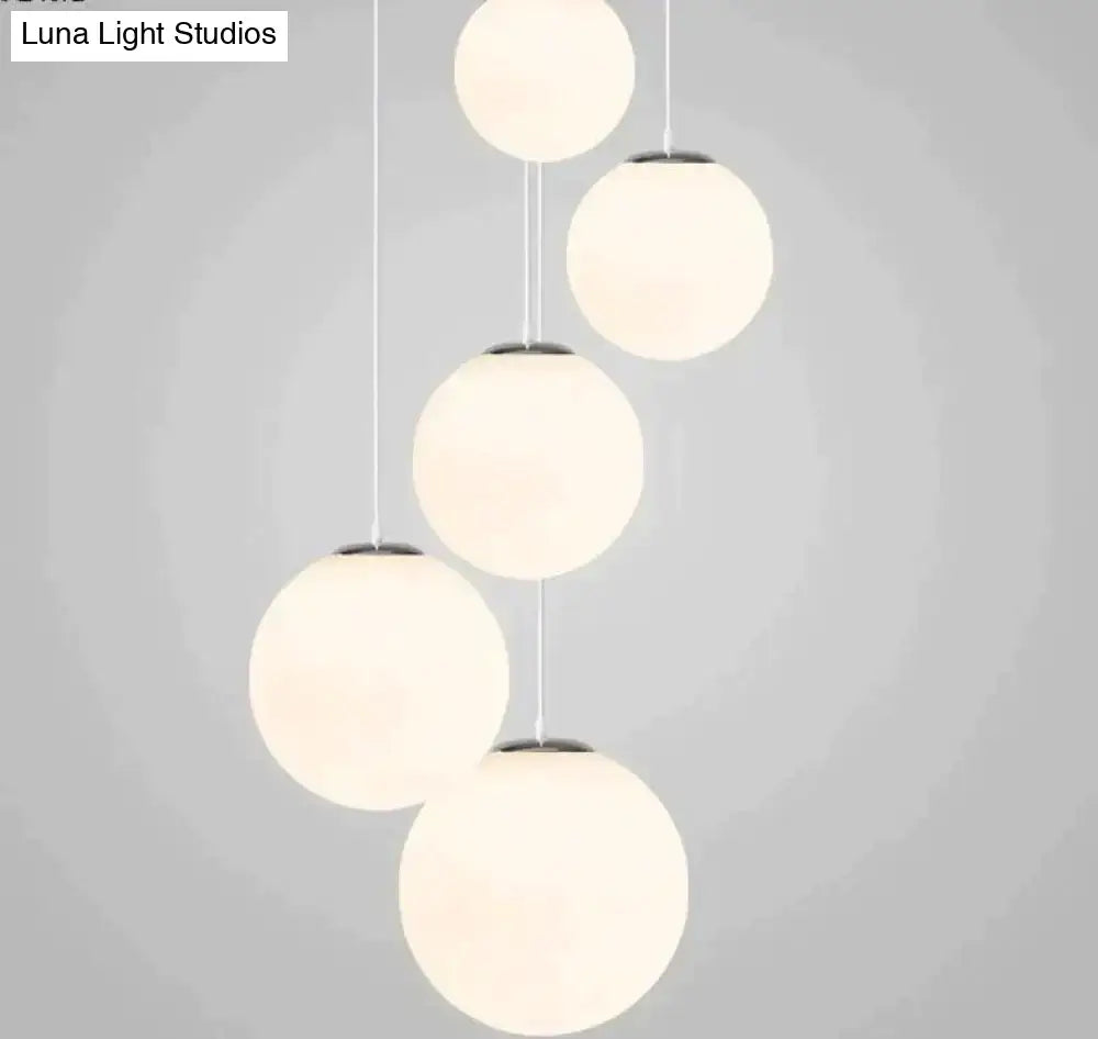 Modern nordic white glass ball pendant lights with five frosted glass globes and metallic accents for living room use