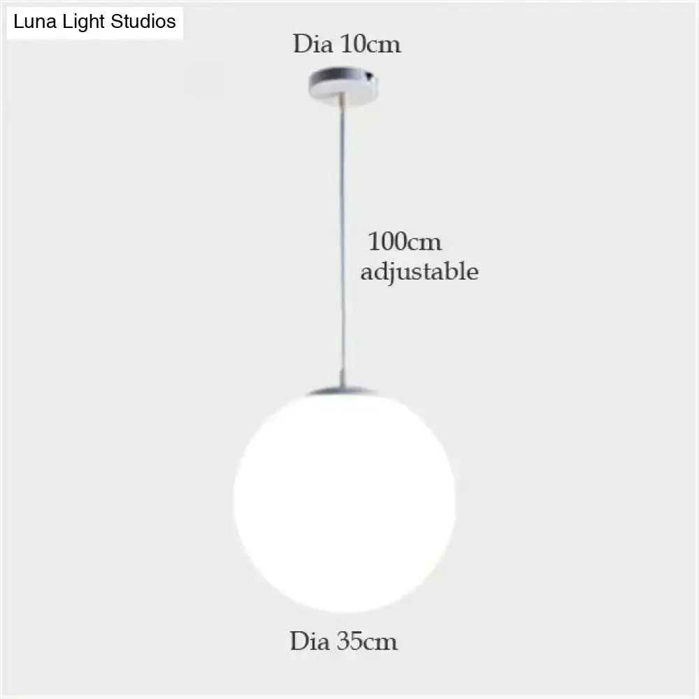 A sleek nordic white glass ball pendant light with frosted glass globe and chrome hardware for modern interiors