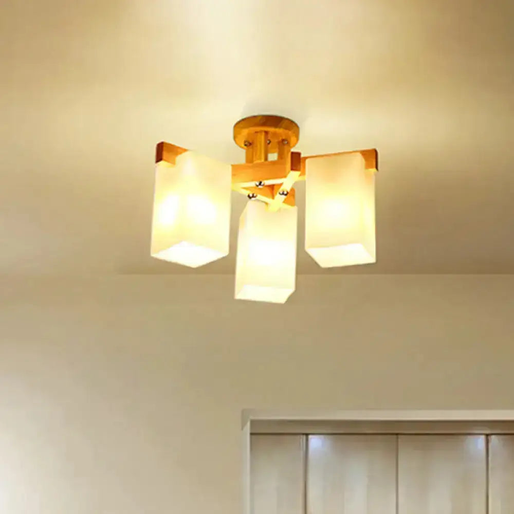 Nordic wood ceiling lamp with warm-toned finish and three cuboid cream glass shades for living room lighting