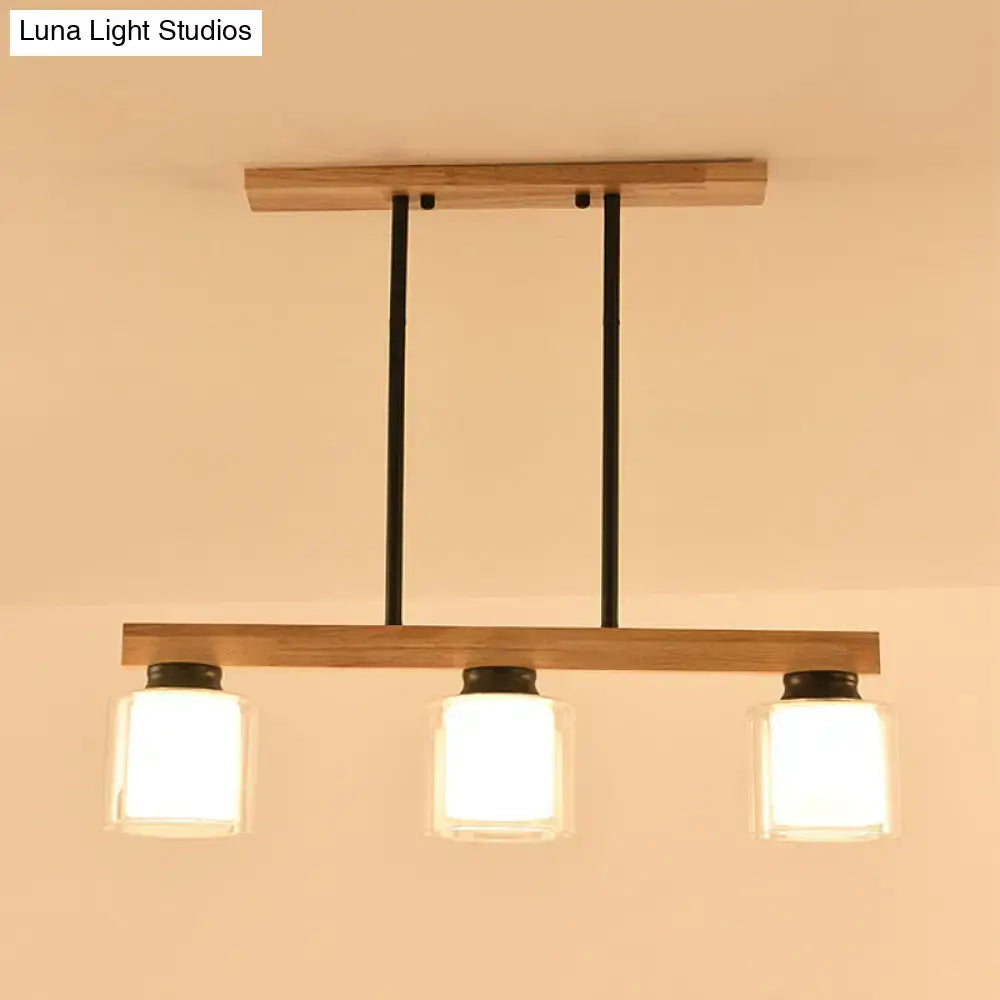 Modern wooden pendant light with three frosted glass shades and black metal accents for restaurant island lighting