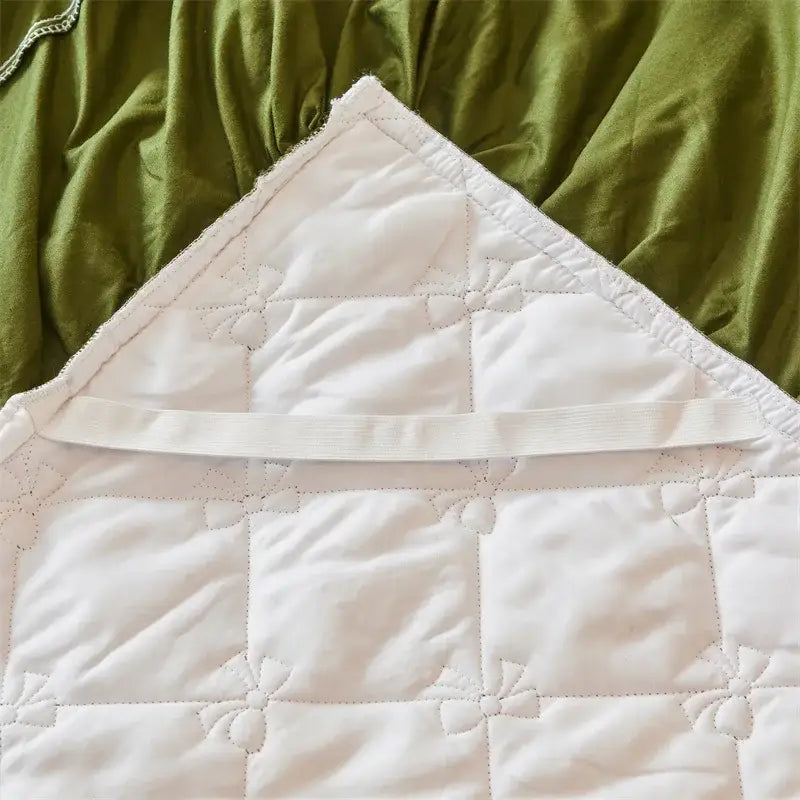 White quilted baby blanket with bow stitching texture complementing olive green and white floral bed skirt set
