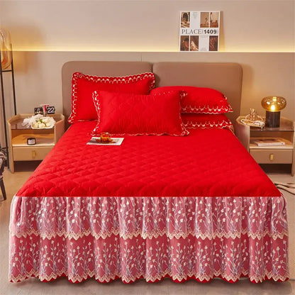 Red quilted bedspread with ruffled lace skirt featuring floral embroidery and scalloped edges in bed skirt set