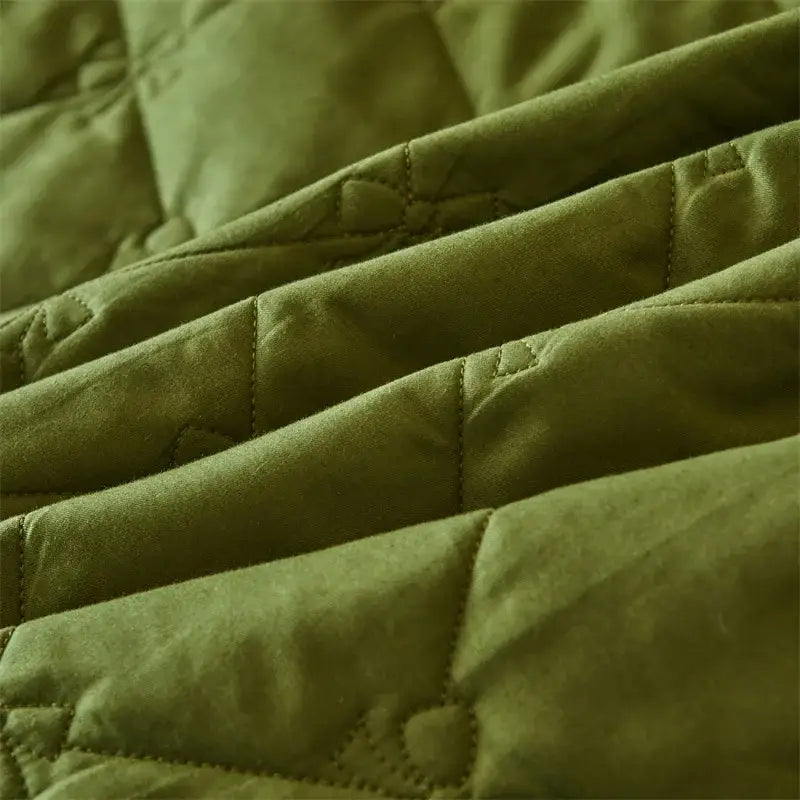 Olive green quilted fabric with visible stitching in a bed skirt set featuring white floral lace trim for bedroom use