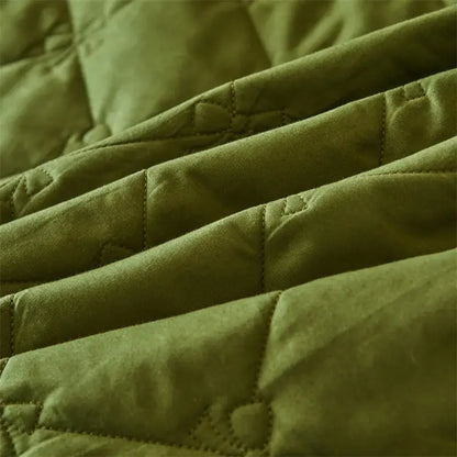 Olive green quilted fabric with visible stitching in a bed skirt set featuring white floral lace trim for bedroom use